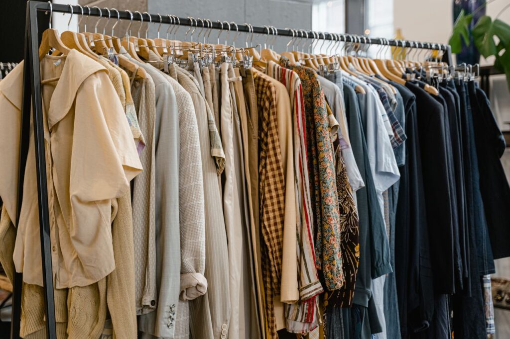 A diverse selection of garments hanging on a clothes rack in a modern fashion boutique.